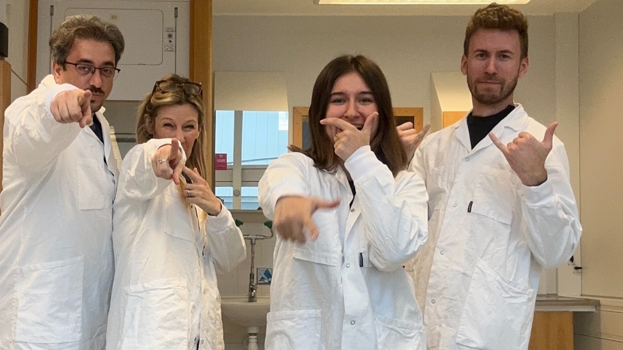 The Lab Donkey team in lab coats pointing at the camera